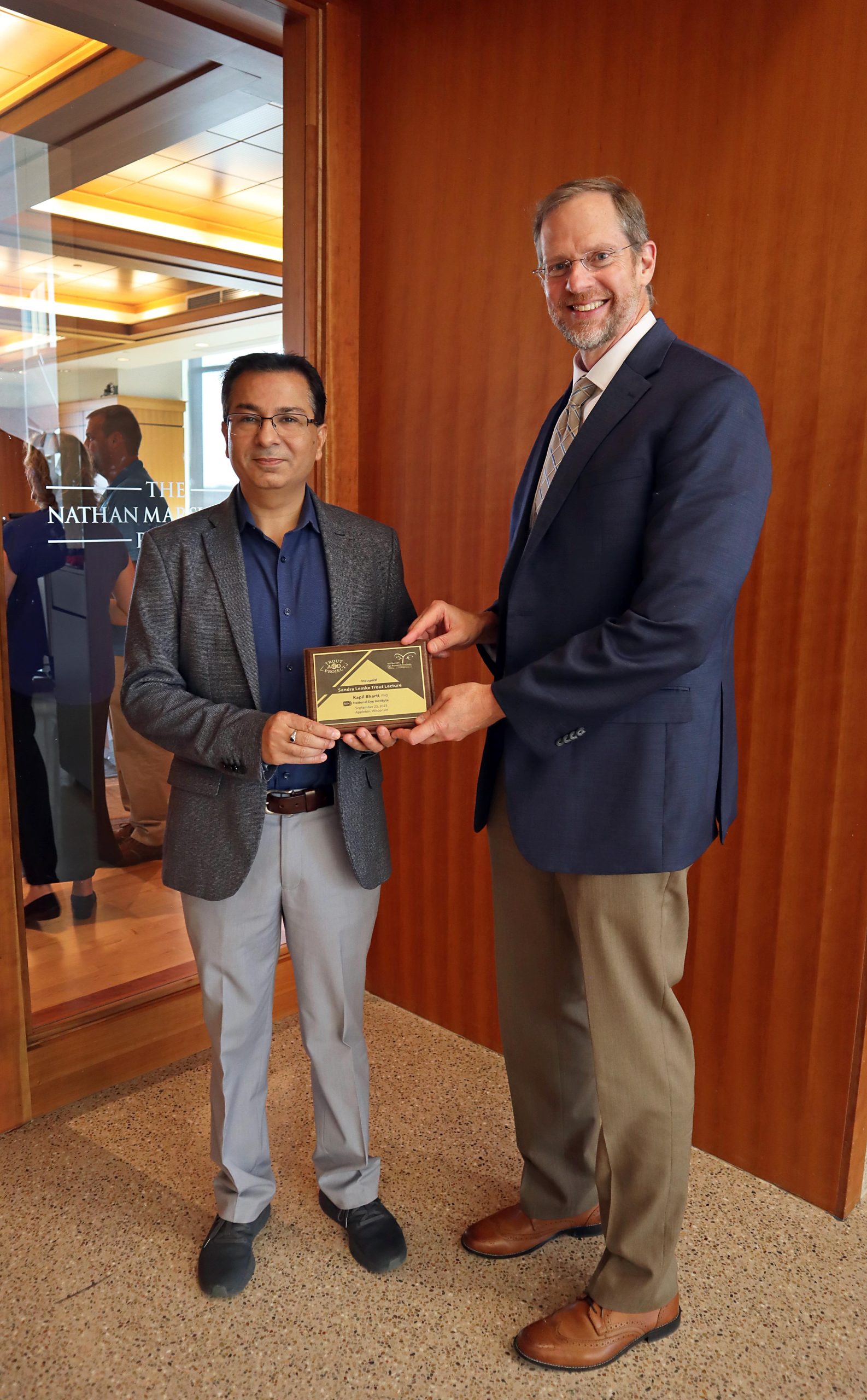 Dr. Kapil Bharti (Director of the National Eye Institute) receives a plaque from McPherson ERI Director David Gamm to commemorate his Inaugural Sandra Lemke Trout Lecture at the Trout AMD Event.