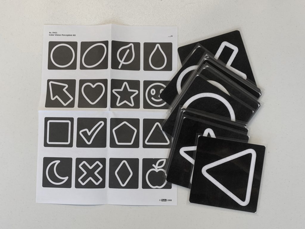 A stack of black laminated cards with white shapes on them. Part of the How We Perceive Color kit.